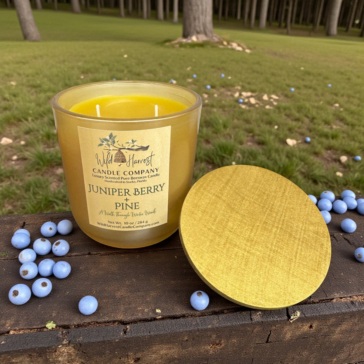 Juniper Berry & Pine candle with a label on a wooden surface outdoors