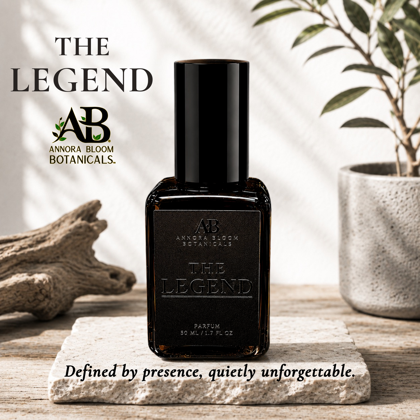 A bottle of Annora Bloom Botanicals 'The Legend' perfume stands on a stone slab on a wooden surface, with driftwood and a potted plant in the background. Text overlays read 'THE LEGEND', 'ANNORA BLOOM BOTANICALS', and 'Defined by presence, quietly unforgettable.