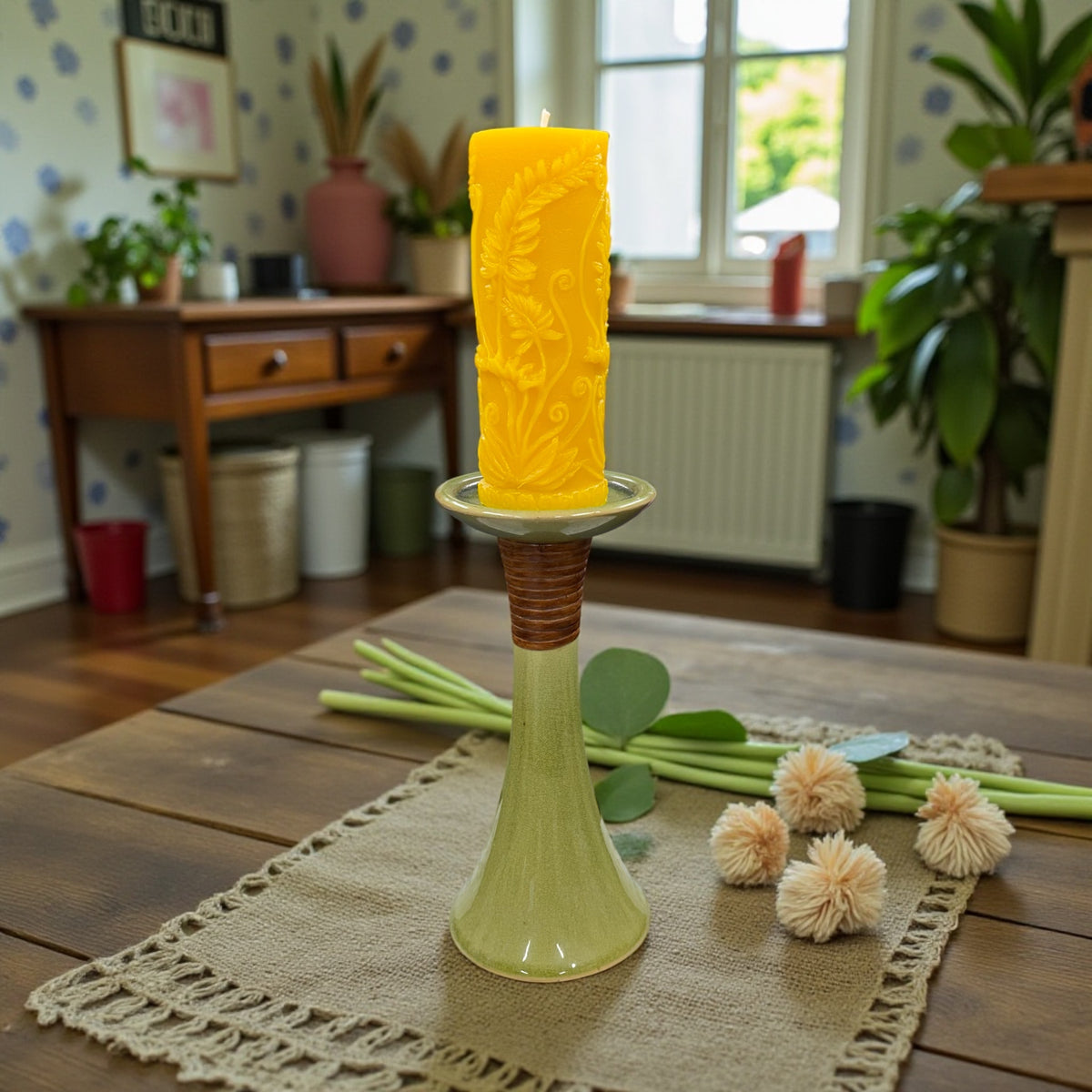 Yellow candle on a green candlestick with a home interior background