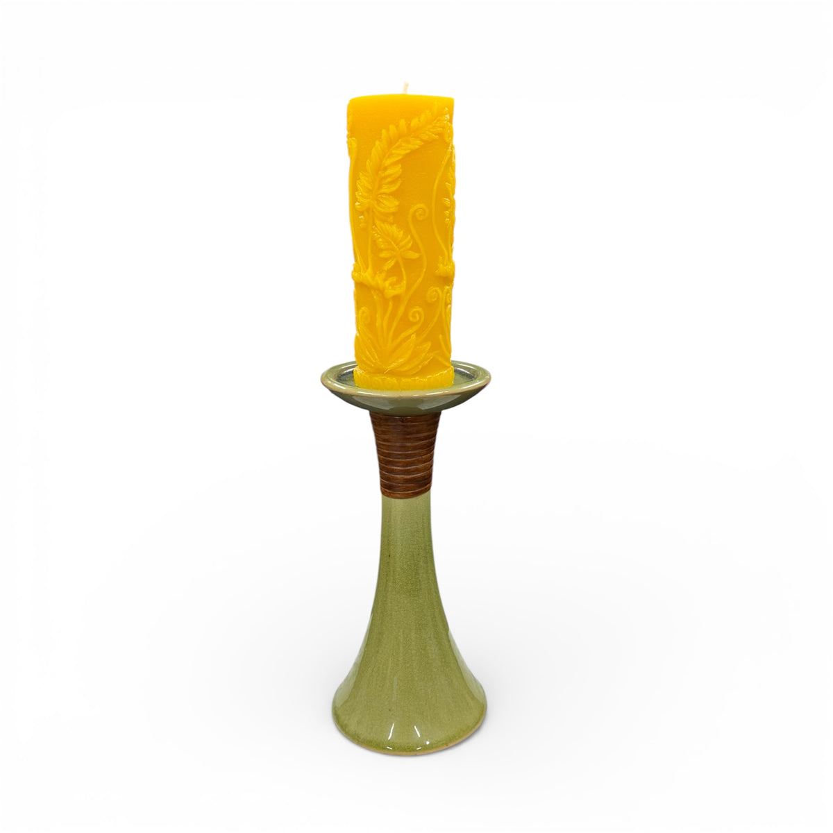 Yellow candle in a decorative holder on a white background