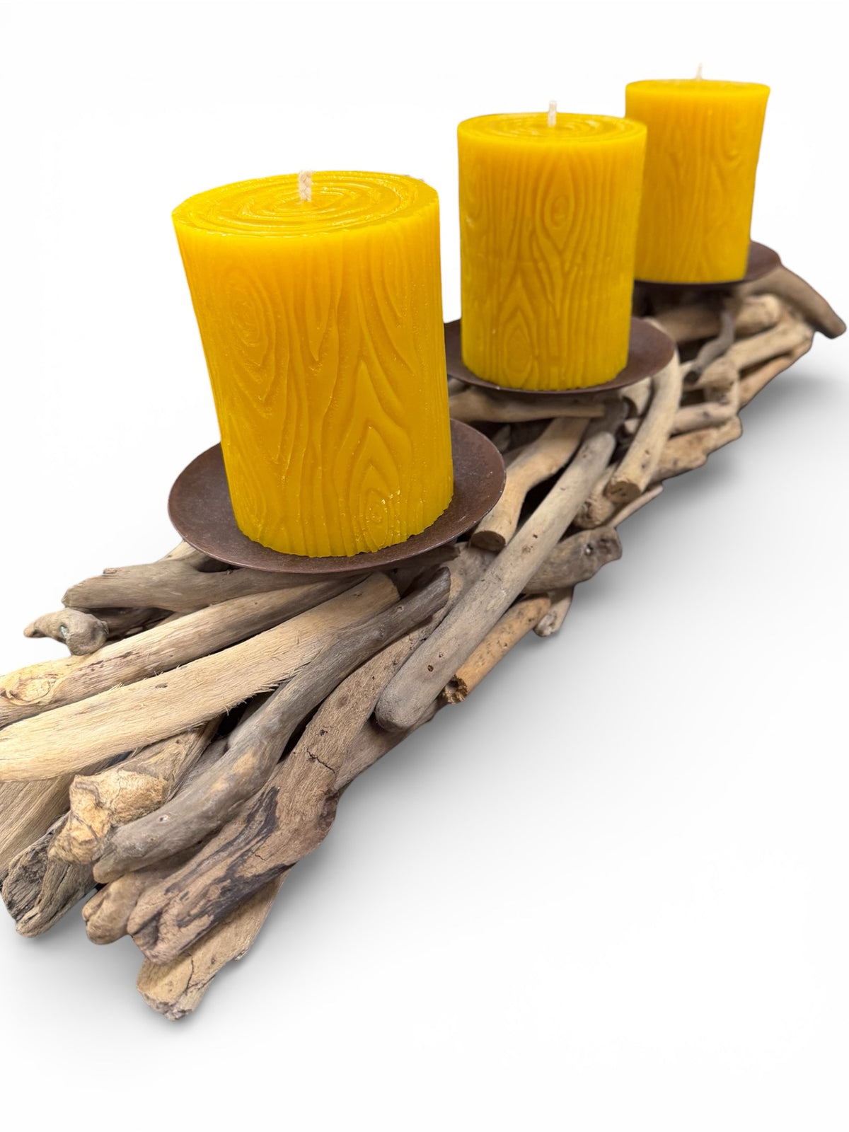 Three yellow candles on a wooden driftwood holder against a white background
